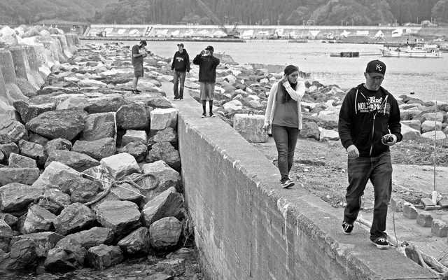 12-1100 Checking out the rebuilt harbor wall in the port of Taro Iwate the old tsumani wall is in the background