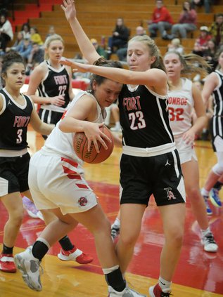 Monroe’s Allison Wunschel gets double teamed on the block by Fort Atkinson’s Elly Kohl (23) and Elliana Rios (3) in the first half of their game Dec. 10.